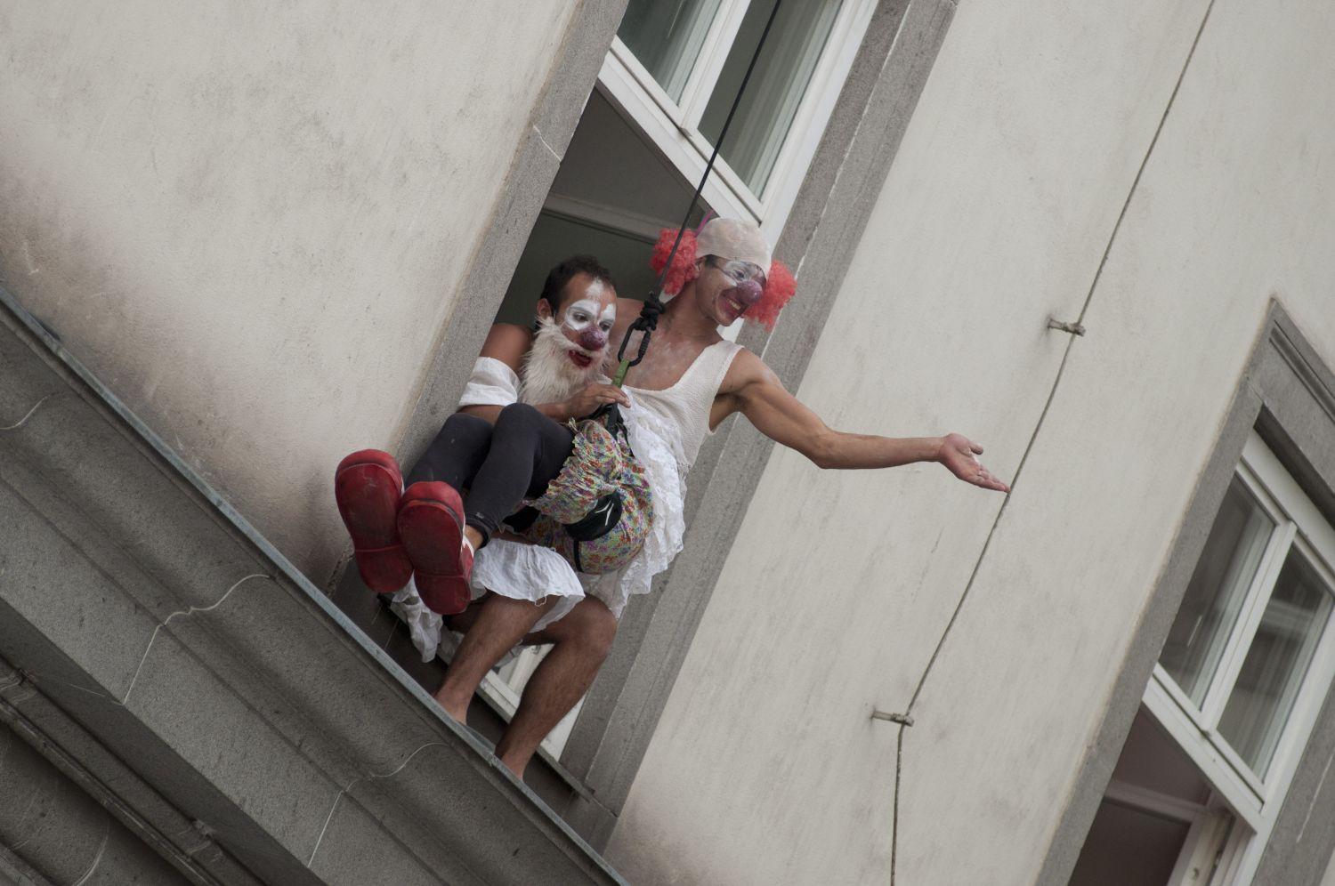 Zwei Clowns sitzen am Fenster der Kunstuniversität Linz