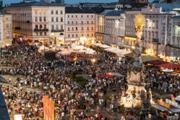 Der Hauptplatz Linz voll mit Menschen an einem lauen Sommerabend